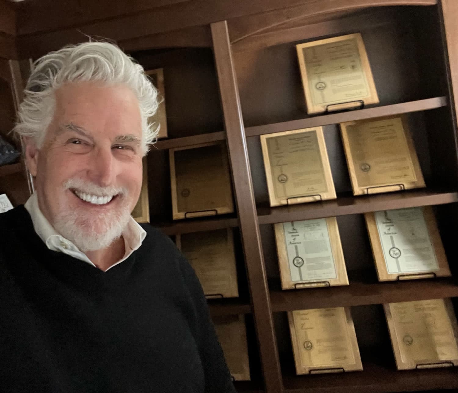 Stephen Key standing in front of framed patent plaques