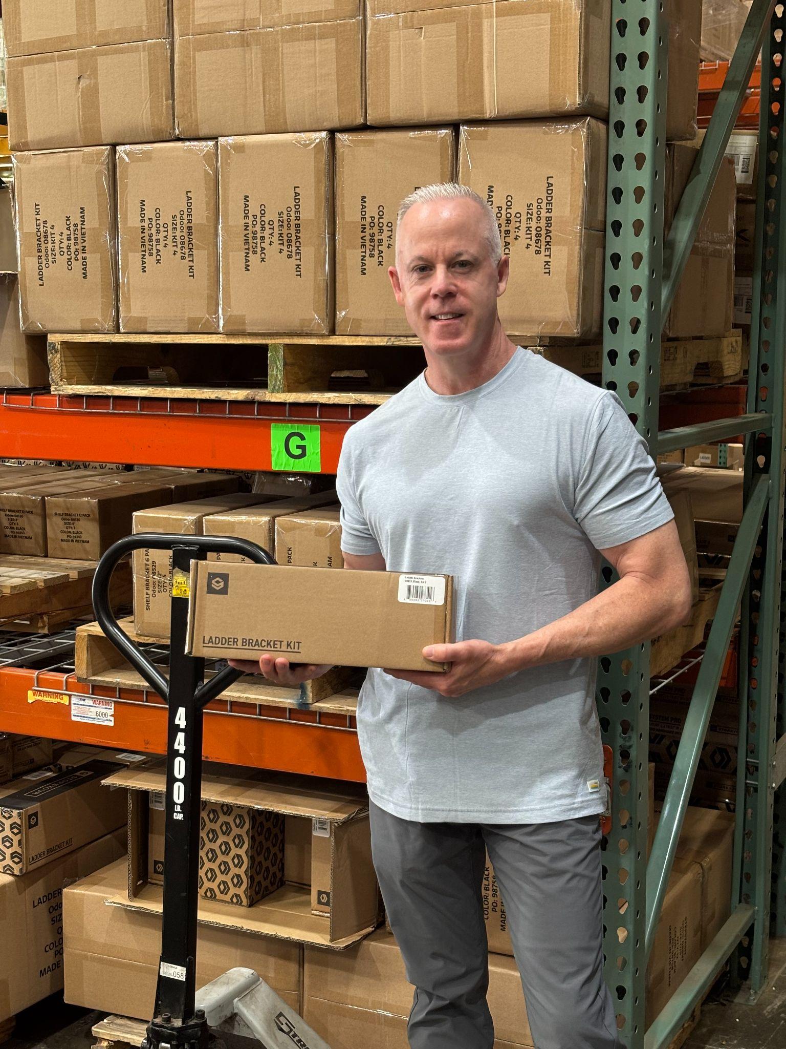Frank Rathgeber holding a packaged product in the warehouse